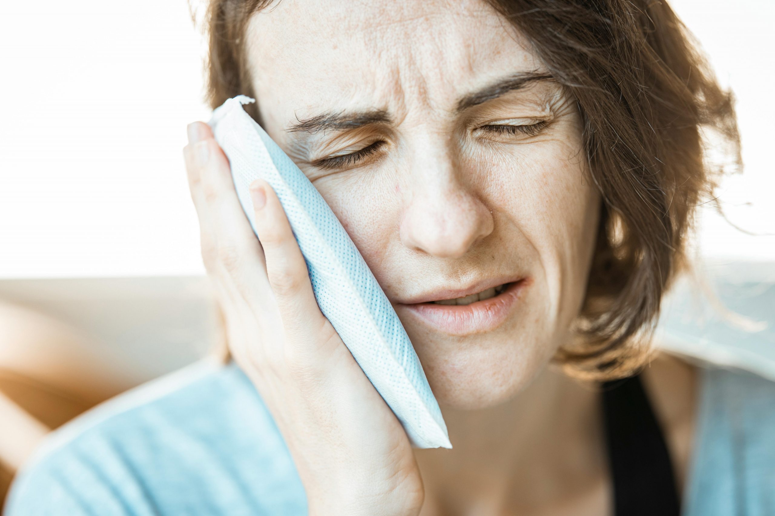 woman holding an ice pack to her jaw