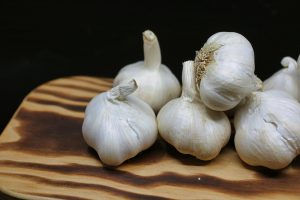 garlic bulbs on a wooden chopping board